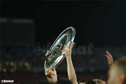 ملعب كرة قدم مضاء ليلاً مع شعار الدوري المصري الممتاز