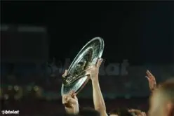 ملعب كرة قدم مضاء ليلاً مع شعار الدوري المصري الممتاز