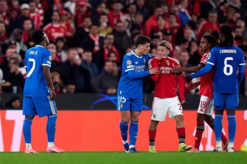 لاعب كرة قدم يغطي فمه أثناء التحدث إلى حكم