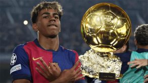 لاعب كرة قدم يحمل جائزة الكرة الذهبية مع خلفية لدوري أبطال أوروبا