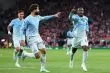 كرة قدم في وسط الملعب مع شعارات أندية مانشستر سيتي وباريس سان جيرمان وروما وريال مدريد